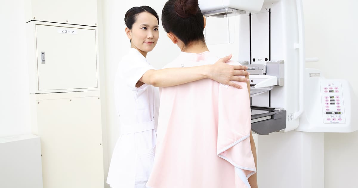 woman preparing with a nurse for a breast scan