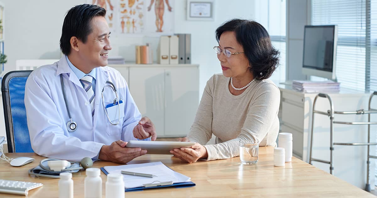 asian doctor speaking to a female patient