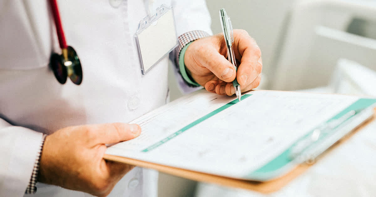 doctor taking notes on clipboard