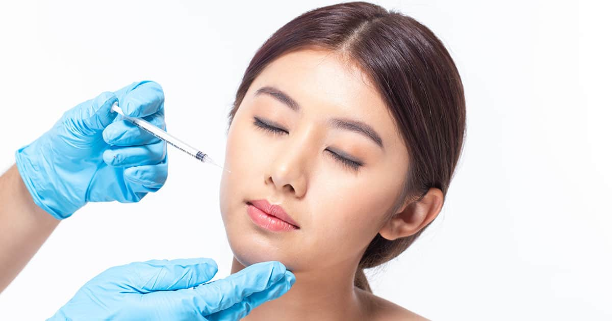 asian woman injecting fillers