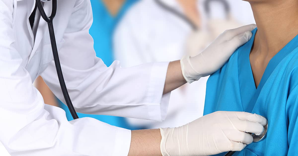 doctor using stethoscope to check patient heartbeat