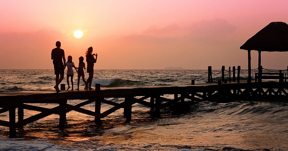 a family with two children walking on a beach boardwalk