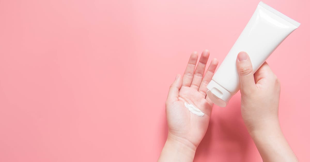 a woman squeezing a tube of cream