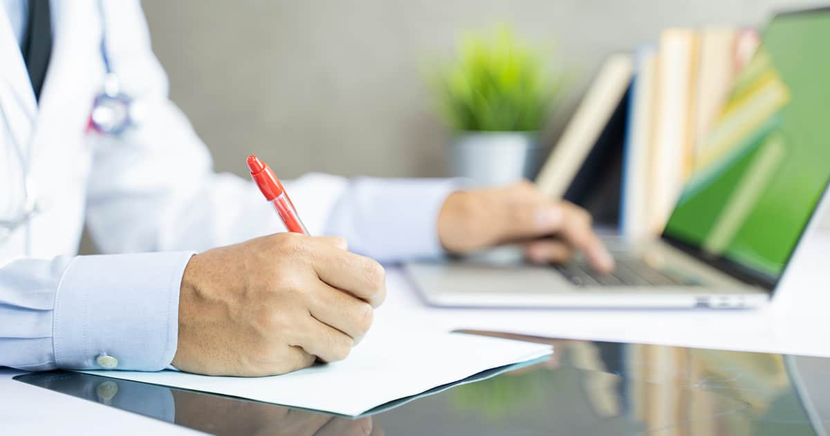 a doctor writing with red pen