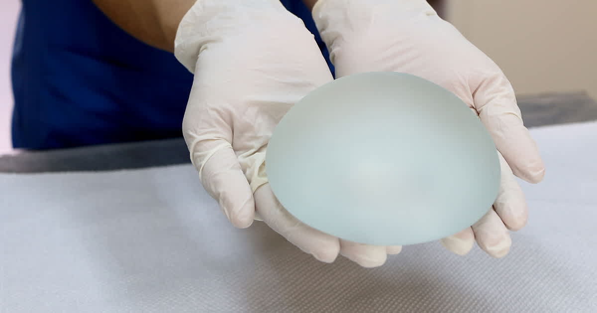 one breast implant in gloved hands