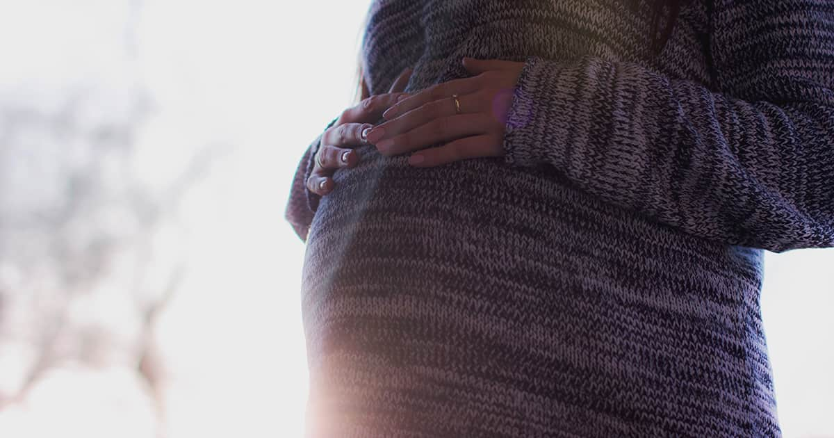 pregnant woman holding onto belly