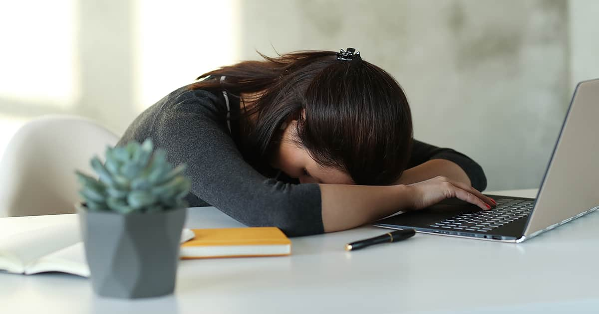 young asian female lying on office desk