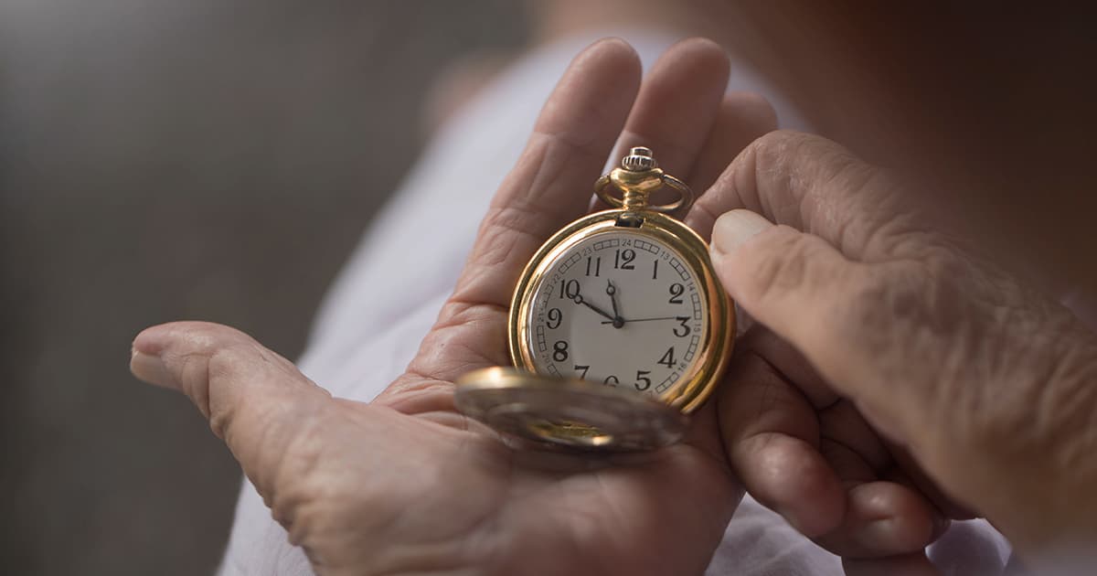 old woman holding vintage clock in hand