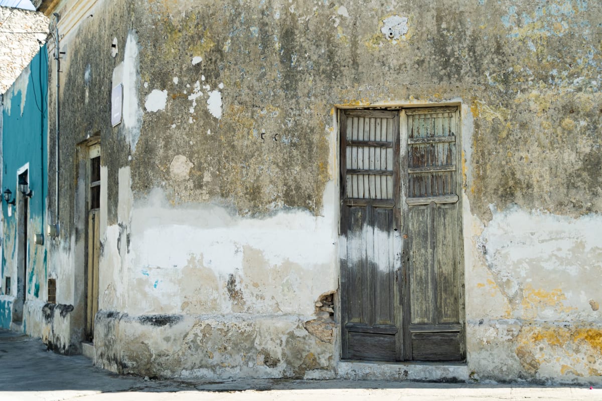 Mur colonial décrépi et vieille porte en bois dans une rue de Mérida, ville qui offre de nombreuses options d’école d’espagnol