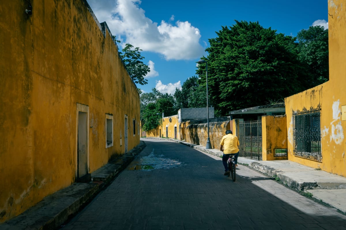 Un ciclista en una calle de muros amarillos en Izamal, un pueblo de Yucatán a una hora de Mérida