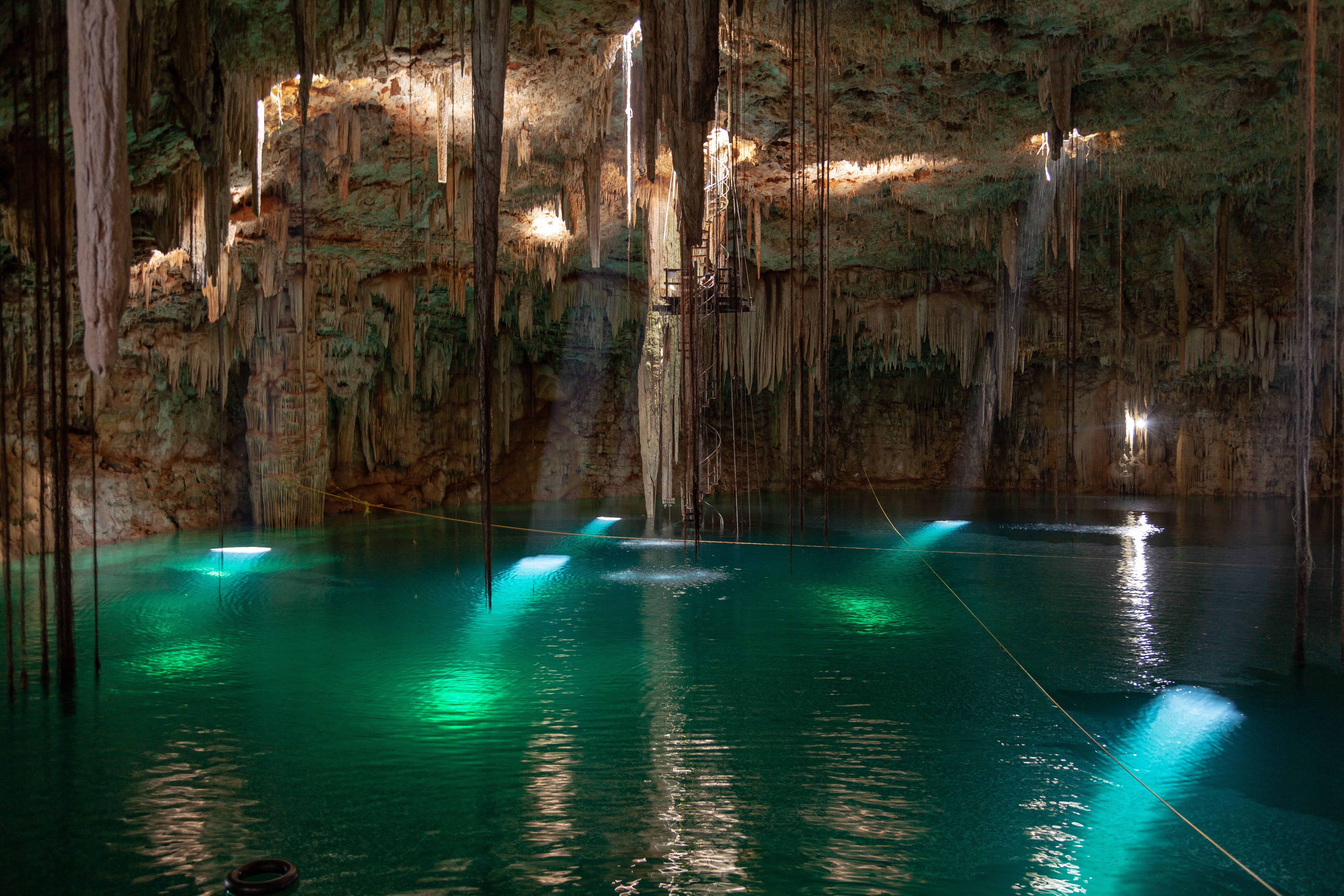 Gran Cenote turquoise freshwater pool with stalactites and jungle vegetation around it