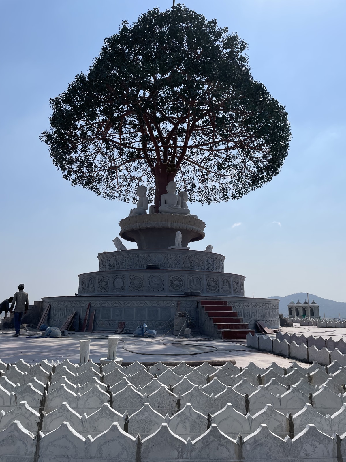 A sculpted tree monument over Tirthankara figures at the Mandaragiri Jain complex near Tumkur