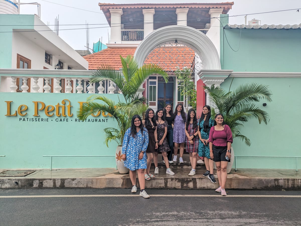 A pastel colonial café building with a French arch and balustrade in Pondicherry's French Quarter