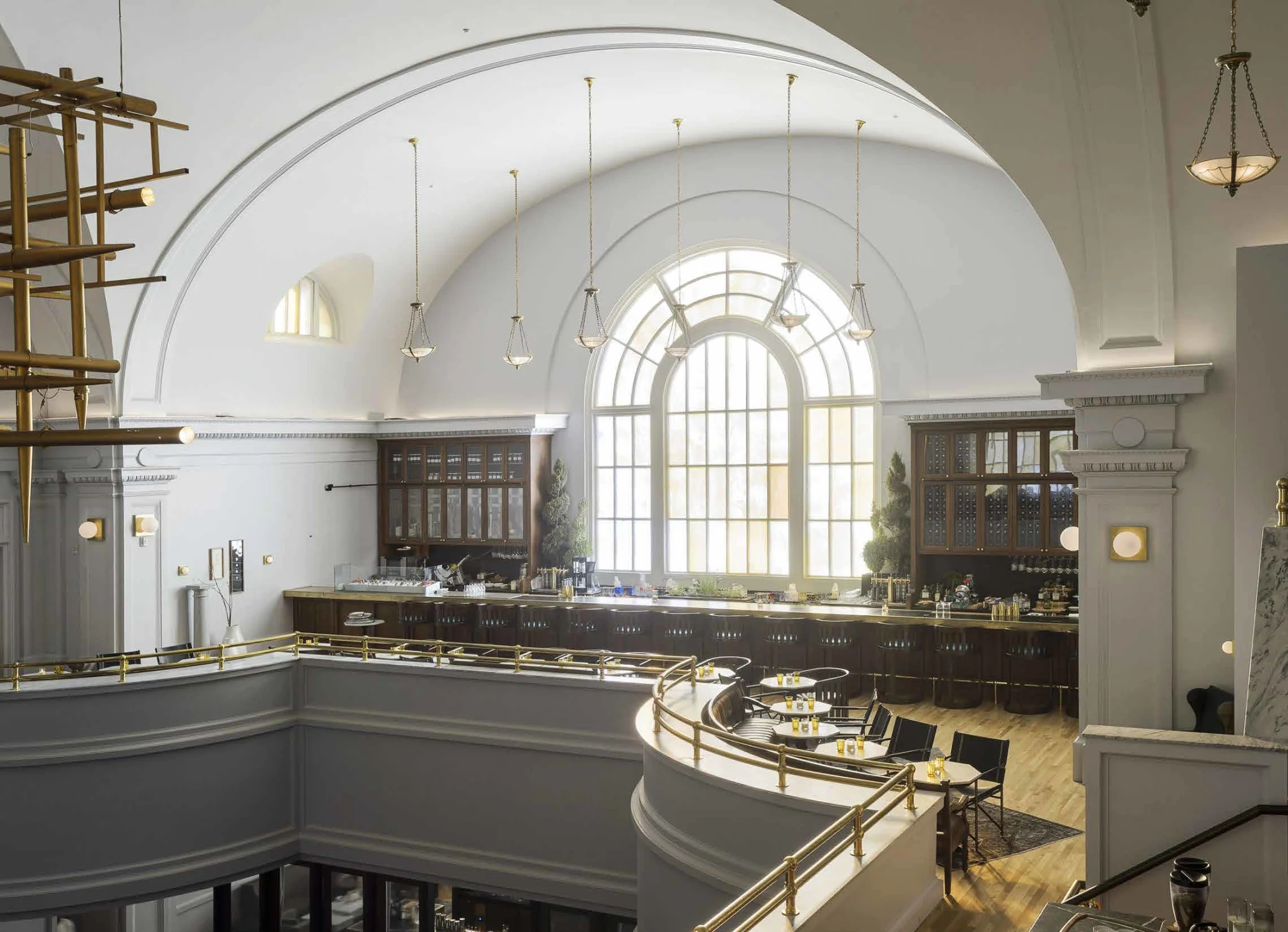 arched ceiling, bar, restaurant, window, arched window, chandelier, gold railing, pendant light