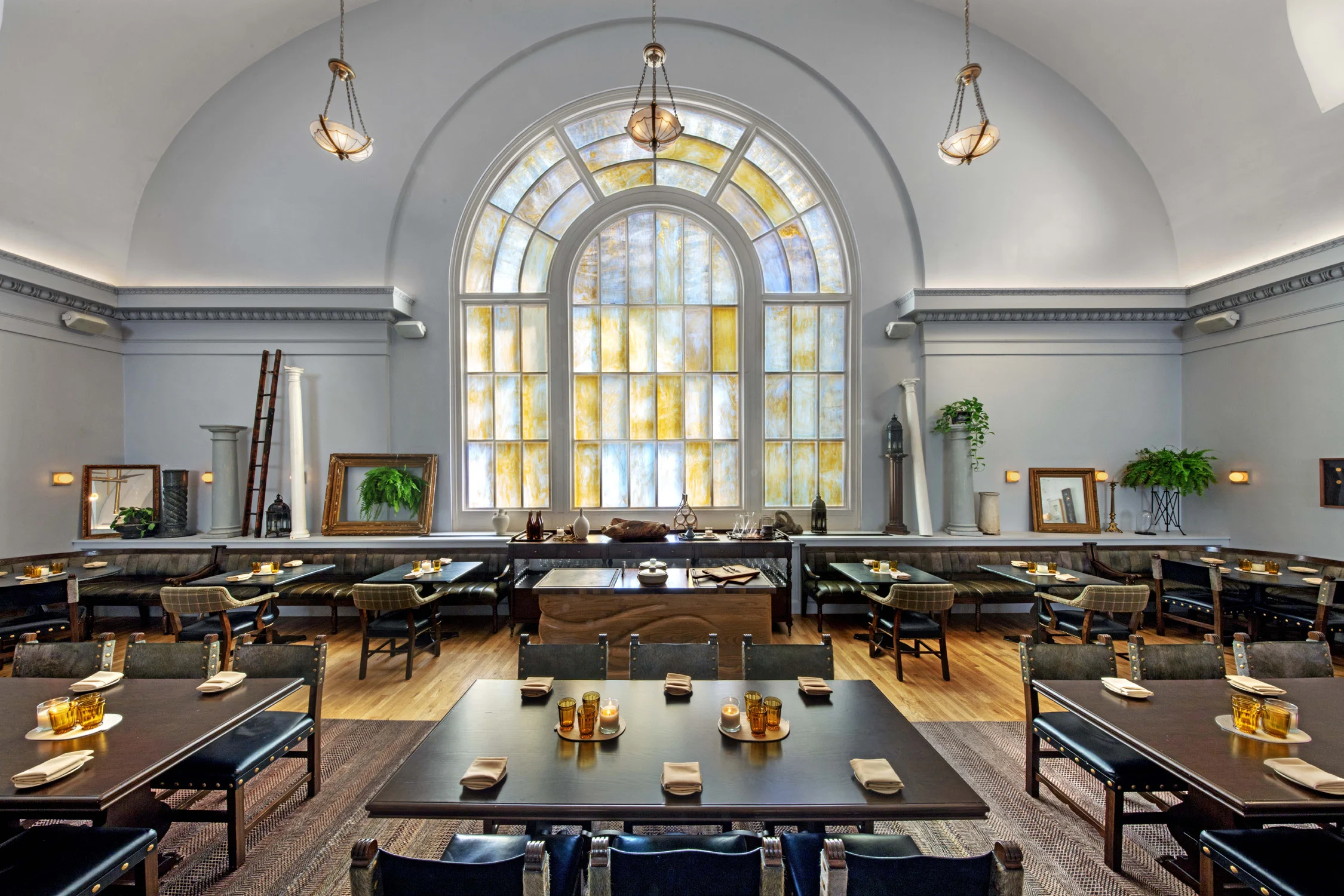 resaurant, stained glass, wood flooring, arched ceiling, tables, chairs, pendant lights, arched window