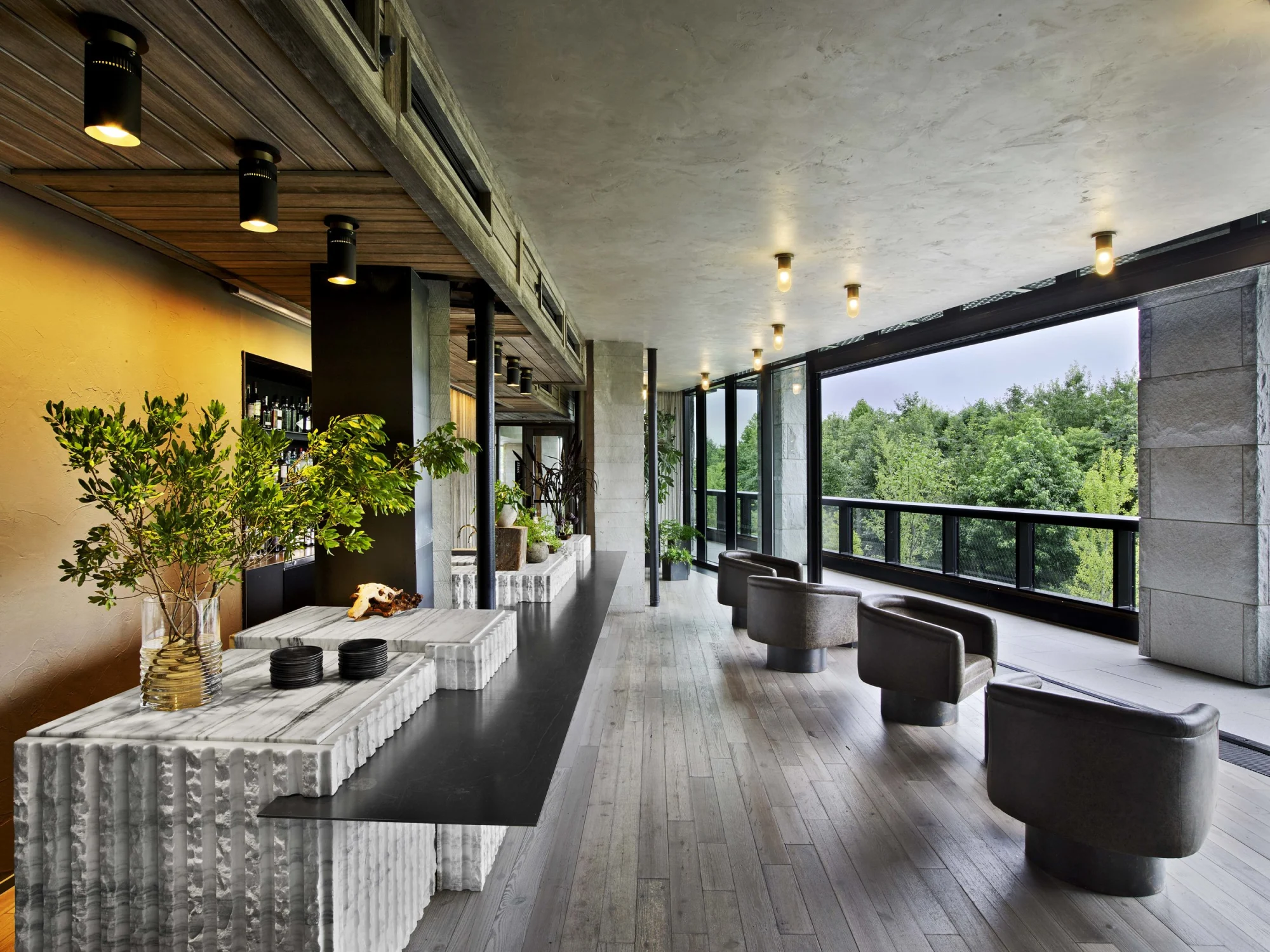 private bar, chairs, counter, stone,concrete,view,wood,leather, greenery, columns