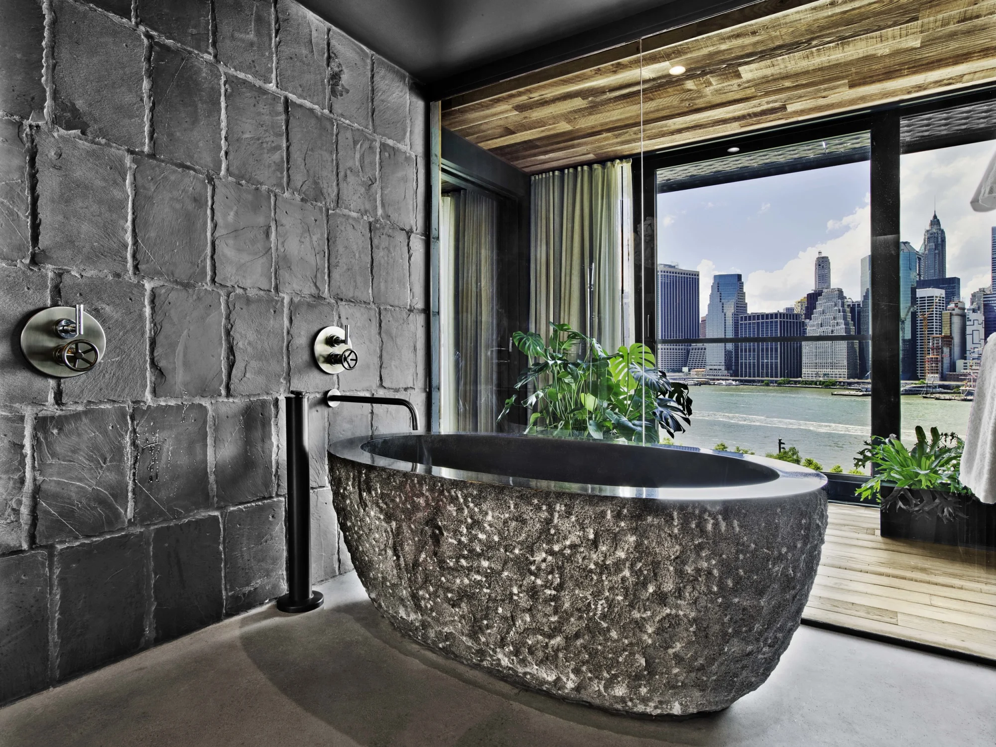 bath tub, stone, view, wood, stone wall, faucet, glass,plants, curtain, river