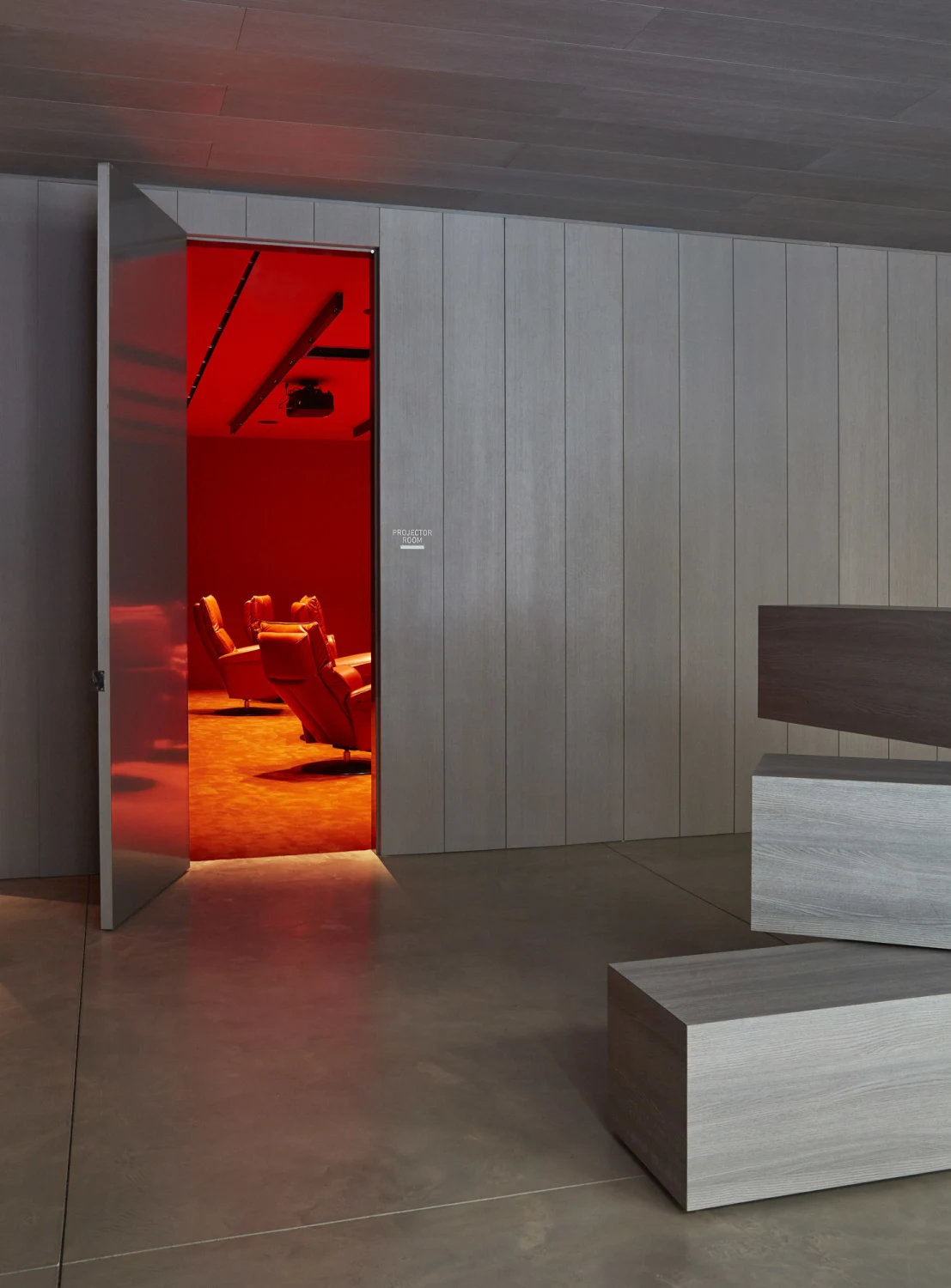 wood, door, art, red,Chairs, celing lights,concrete, pannels,carpet,projector
