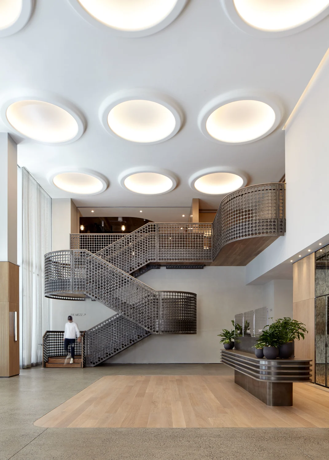 lobby, stair, desk,metal,wood, concrete, plants, celling lights, mirror, door