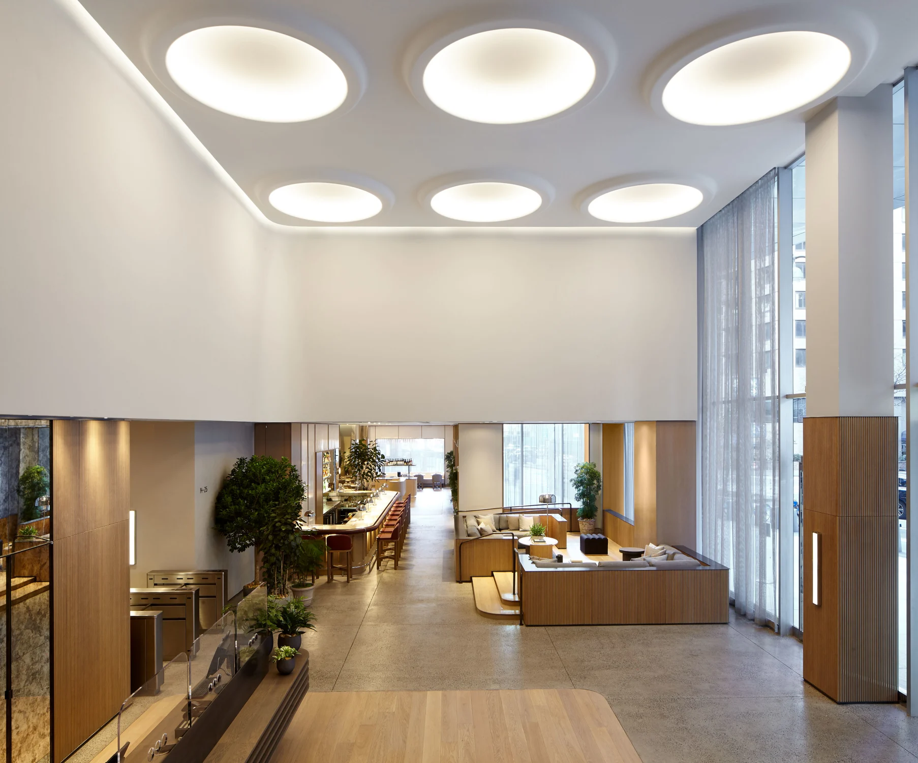 lobby, desk, bar, circles, sofa, reflecting mirror door, plants, pillows, wood, bar stools