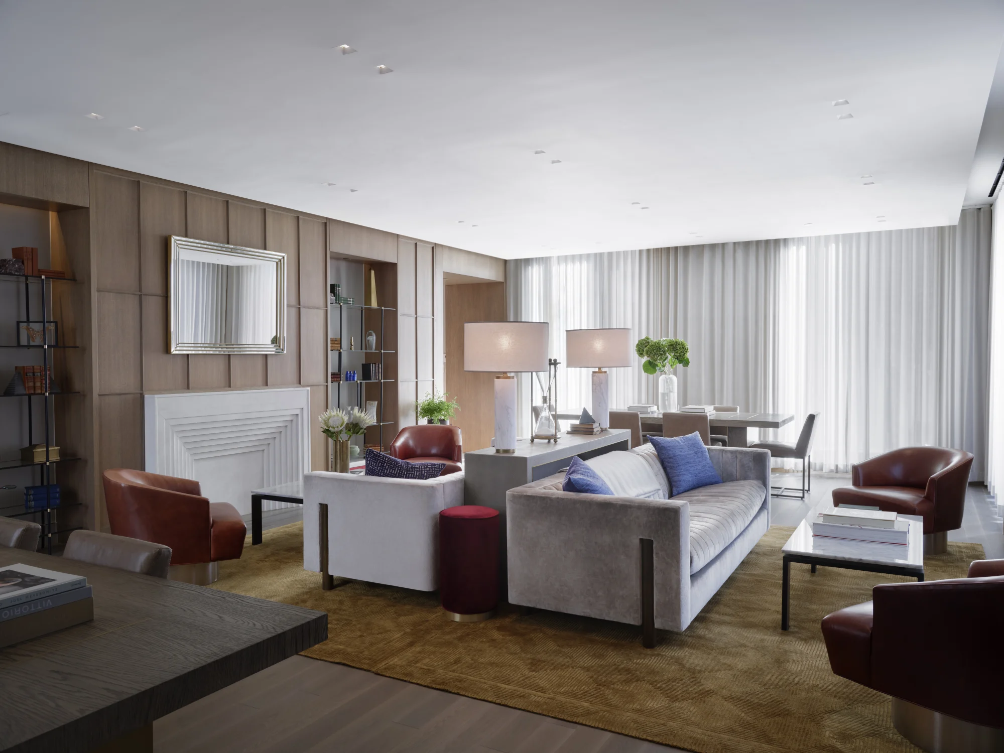 living room, sofa, rug, chair, lamps, wood flooring, drapery, leather sofa chairs, dining table, mirror, niche, shelving, flowers