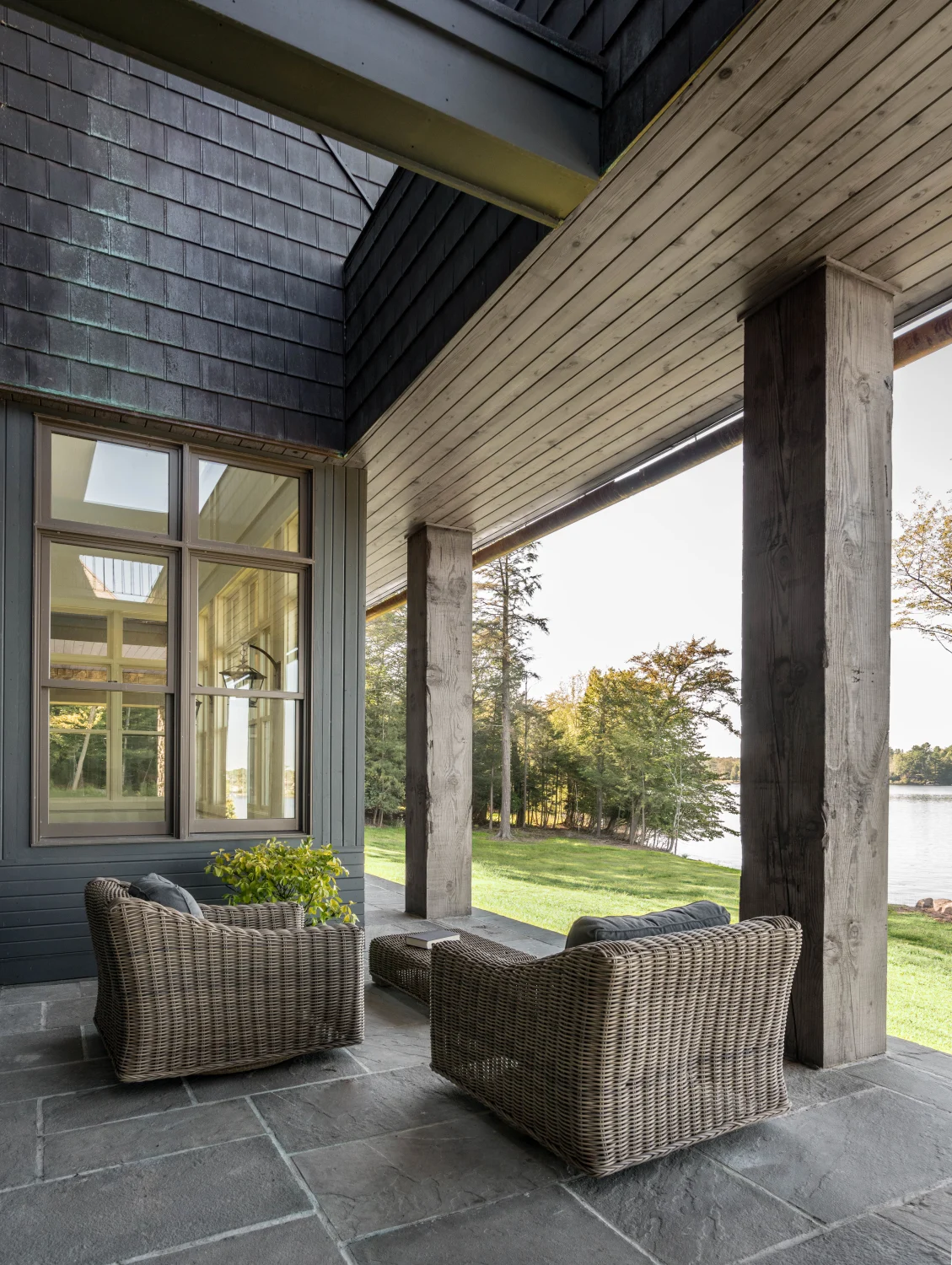copper, shingles, deck, pavers, stone, sofa chairs, columns, beams, wood, lake, lawn, trees, window