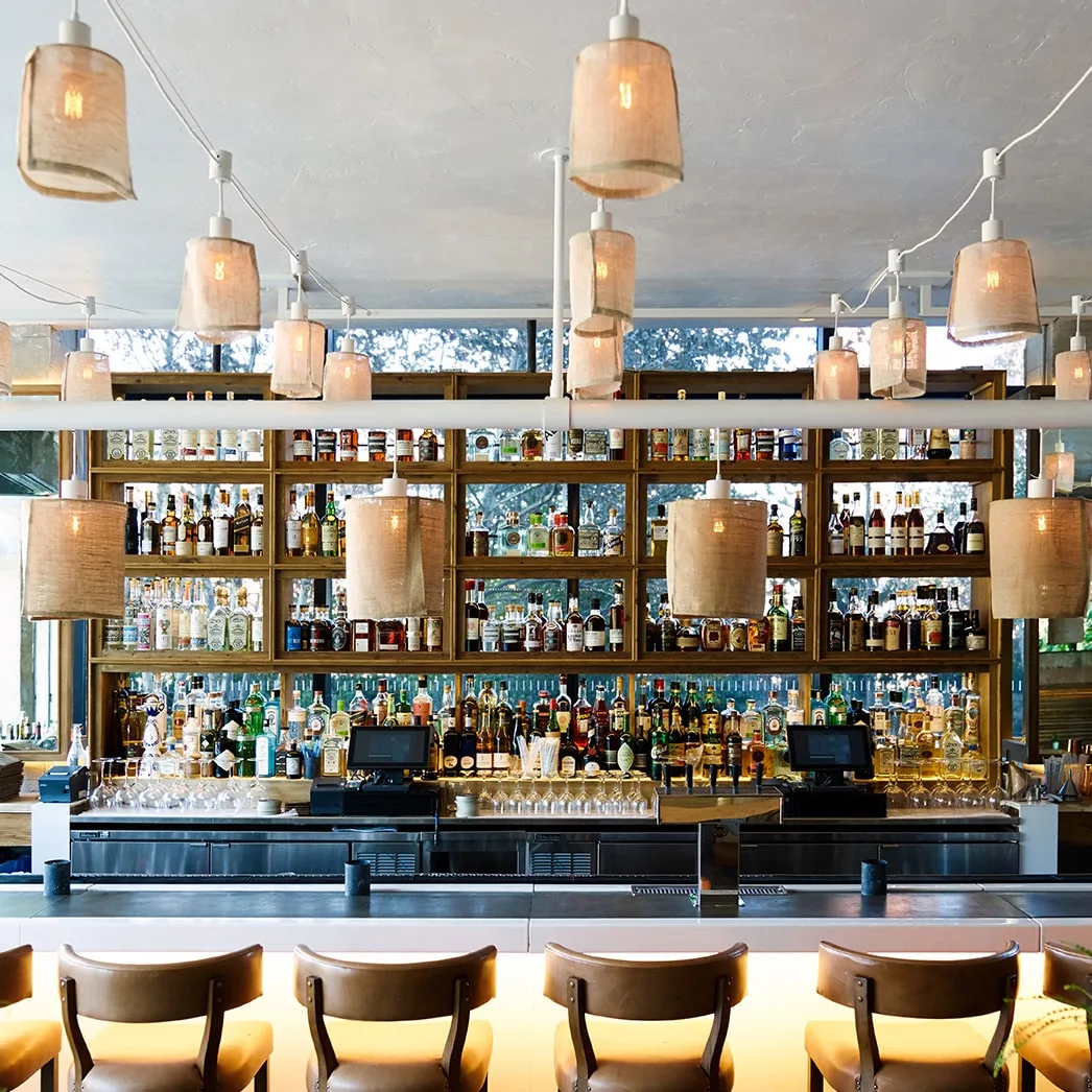 Bar  Bottles  Shelves  Pendant lights  Counter  Stools  Glassware  Cash registers  Wood  Mirrors