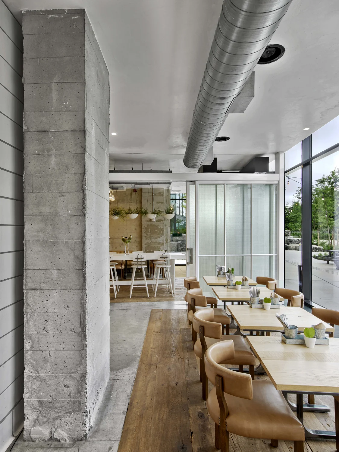 Concrete,  Wooden floor, Dining tables , Leather chairs,  Glass, wall,  Natural light,  Metal duct , Potted plants,  Ceiling lights,  White walls