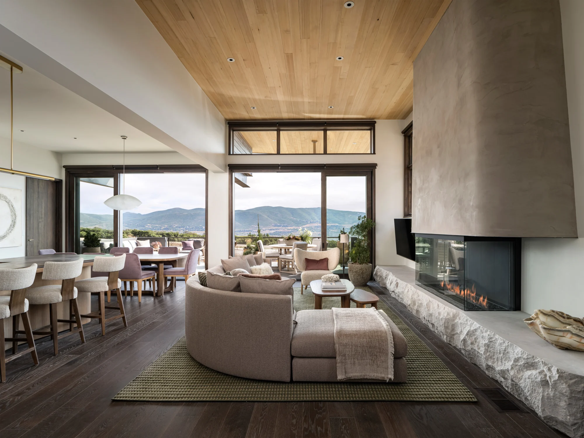 Living room, rug, fireplace, concrete, stone, kitchen, island, chair, terrace, windows, couch, wood flooring
