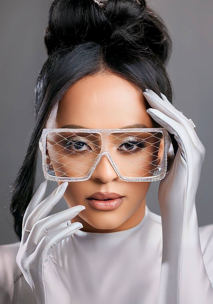 Veronica Adane standing in a black off-shoulder gown against a clean studio backdrop.