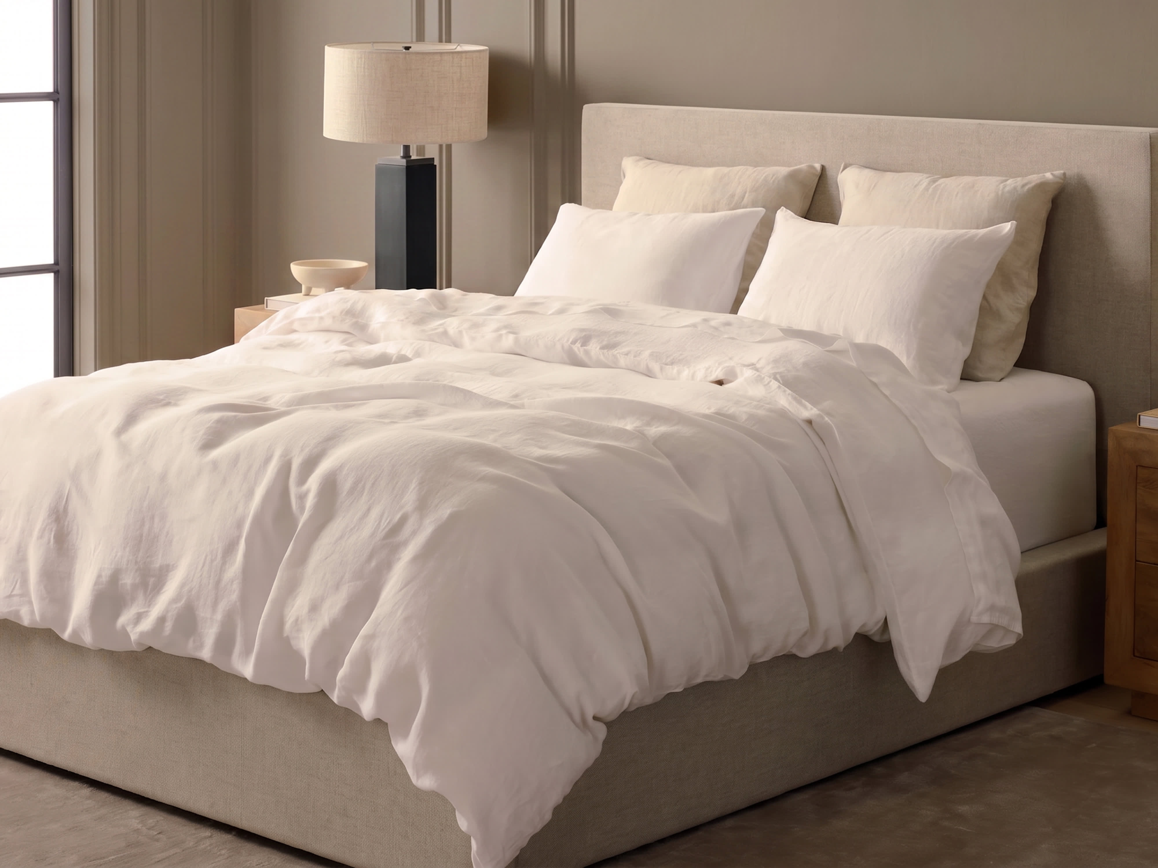 Bed with white bedding and tan bed frame
