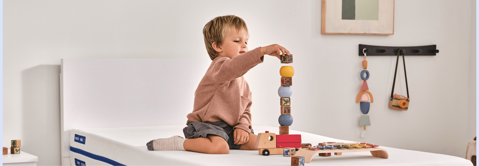 little boy playing with blocks on his Nectar Kids Mattress