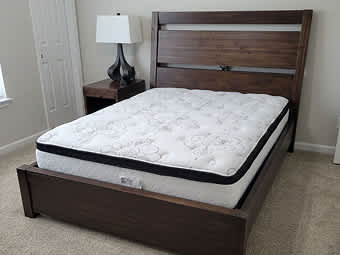 brown wooden bed frame with chime mattress