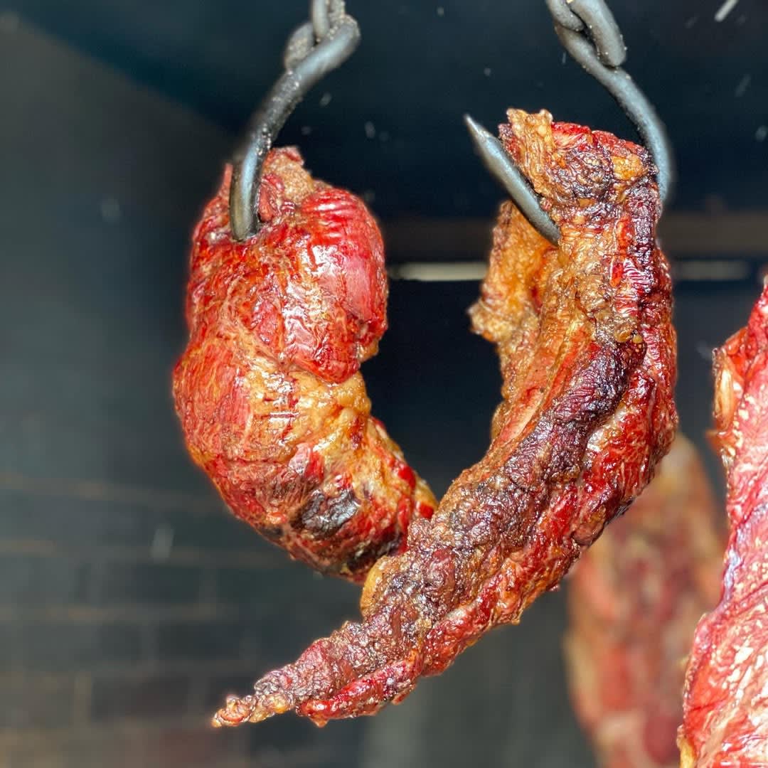 Carne de mamona asada al palo sobre brasa de leña