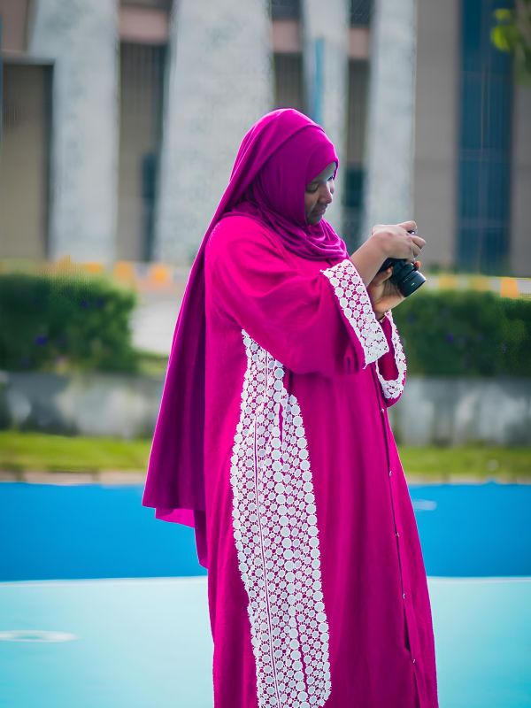 Iklima Babangida reviewing her camera settings outdoors