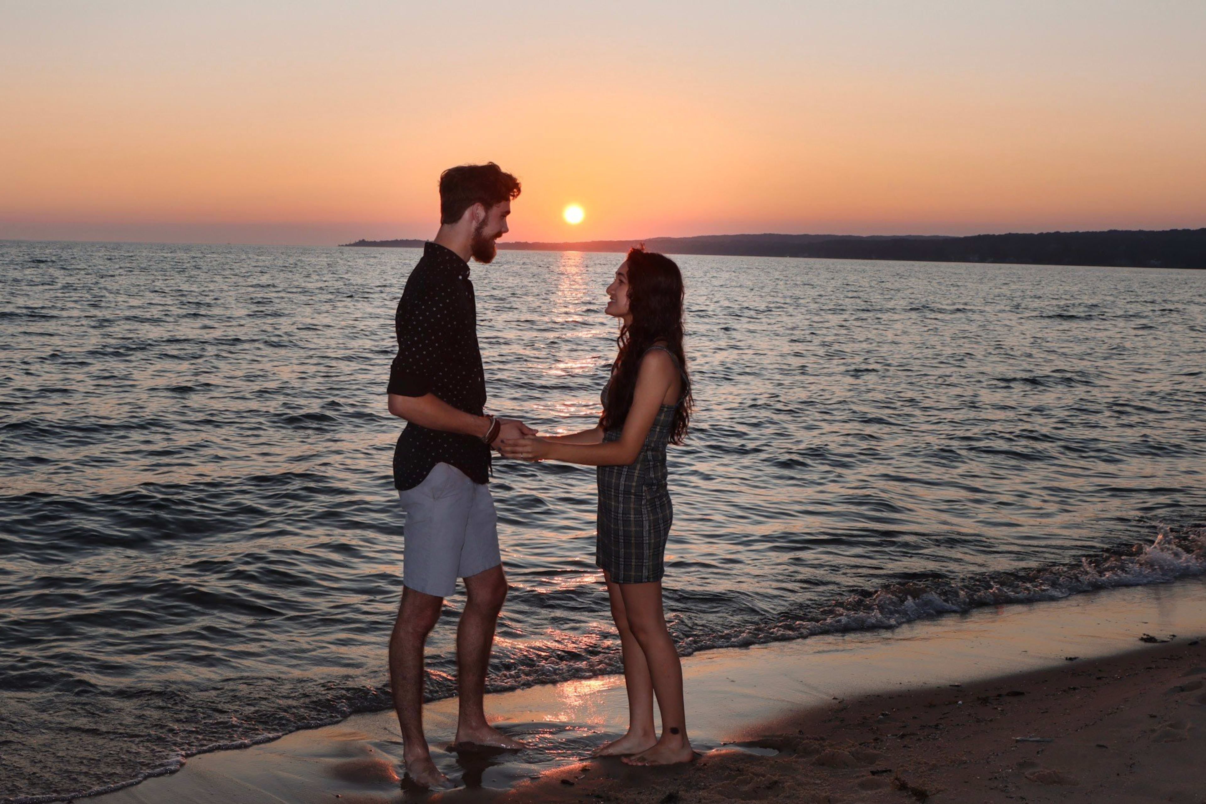 Couple holding hands at sunset on the lakeshore, Metro Detroit engagement session