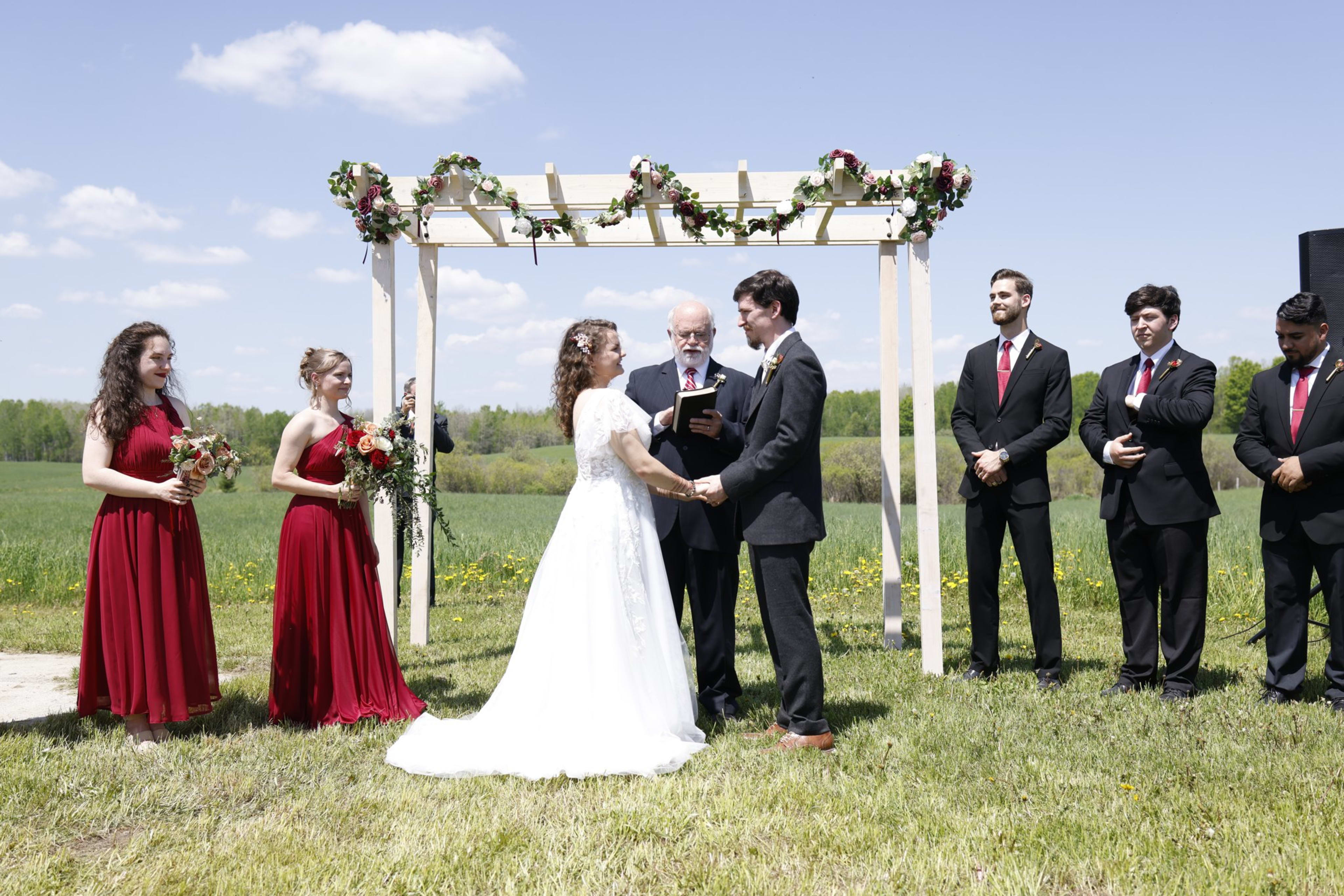 Outdoor wedding ceremony beneath a floral arch, southeast Michigan wedding