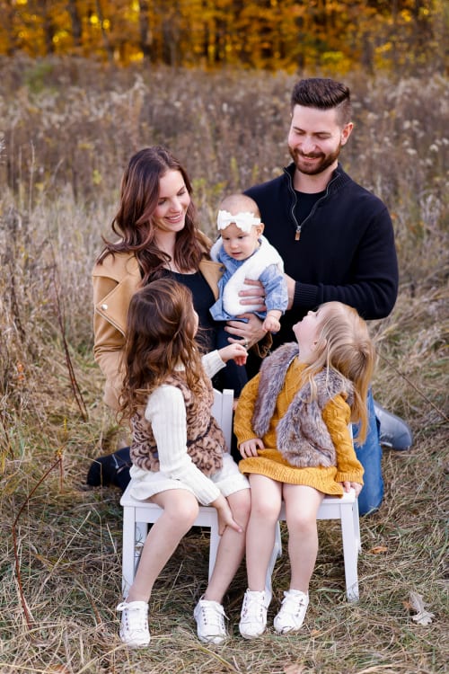 Parents with their three children in a golden field, southeast Michigan family session