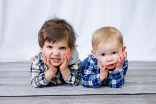 Two young brothers resting their chins on their hands, Metro Detroit siblings session
