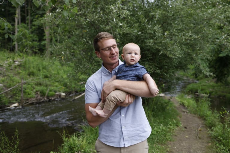 Charles holding baby James beside the creek at Parker Mill in Ann Arbor