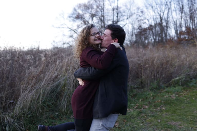 John and Katy embrace during their autumn engagement session at Fillmore County Park