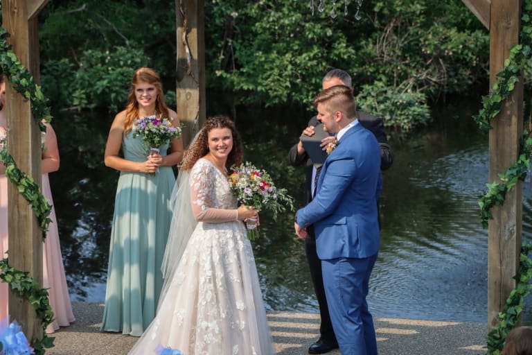 Quintanya with her bouquet beside Scott during their pondside ceremony