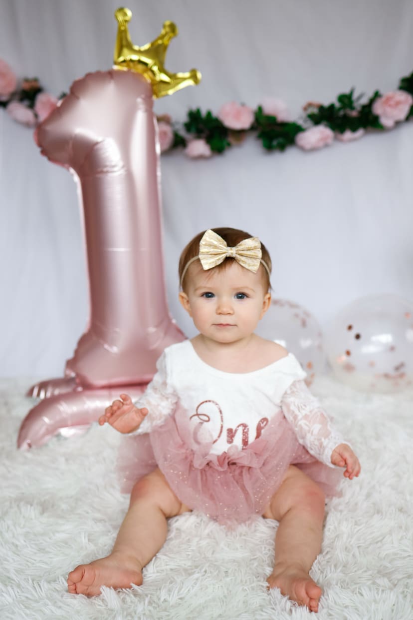 One-year-old girl with a pink number-one balloon at her first birthday, Metro Detroit cake smash session