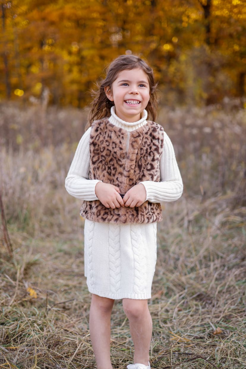 Young girl in a leopard vest and white dress in an autumn field, southeast Michigan family session