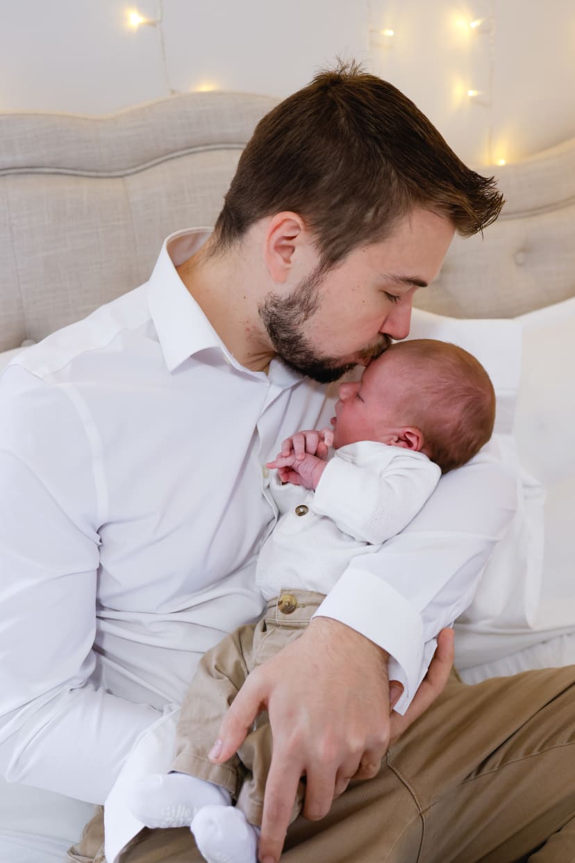 Father kissing his newborn's forehead, Metro Detroit newborn session