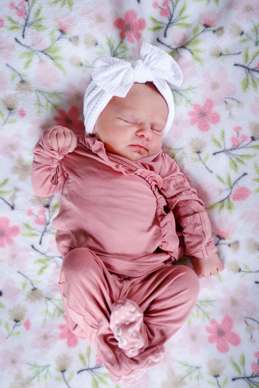 Sleeping newborn girl in pink on a floral blanket, Metro Detroit newborn session