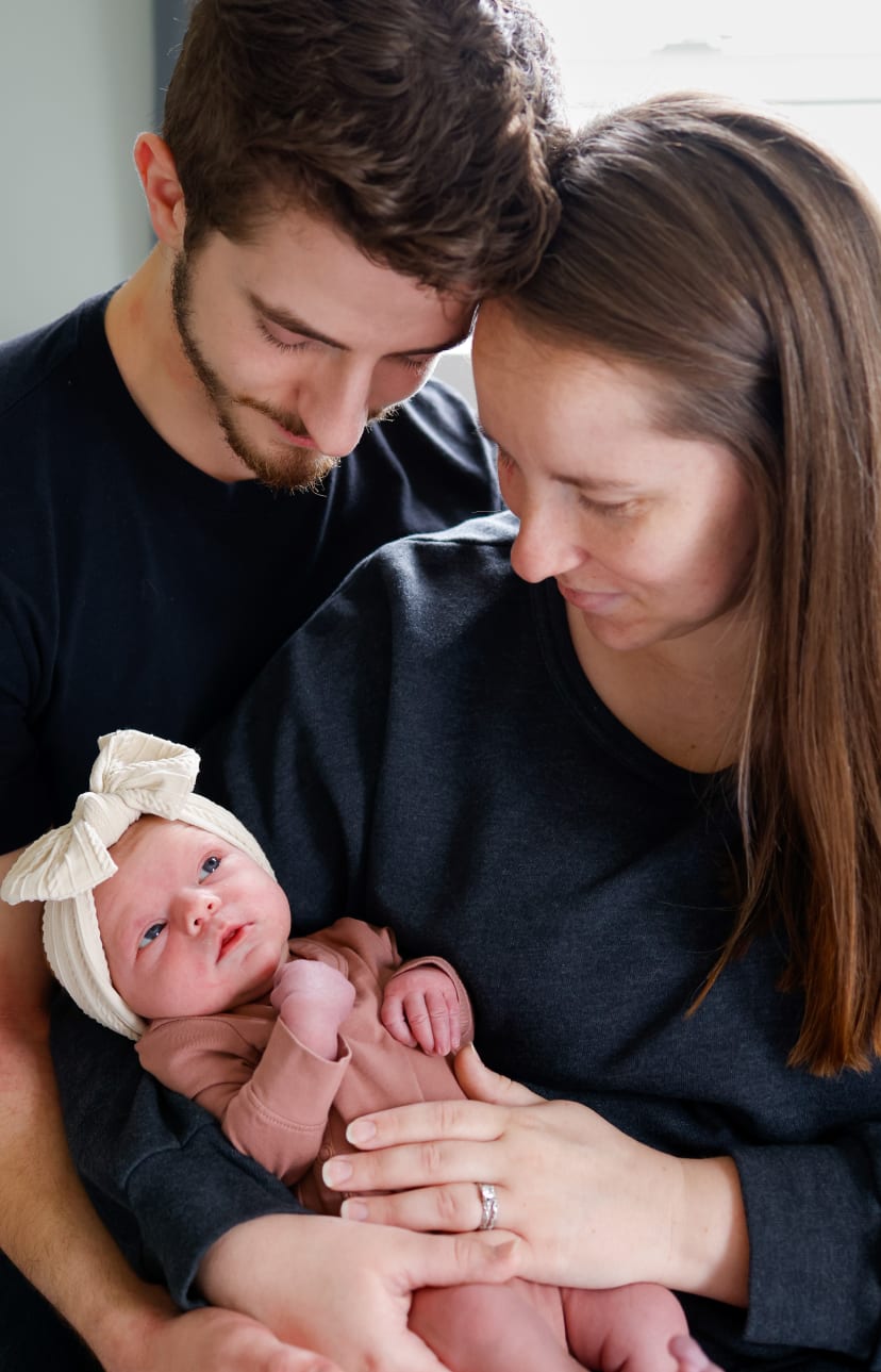 Parents holding their newborn daughter together, Metro Detroit newborn session