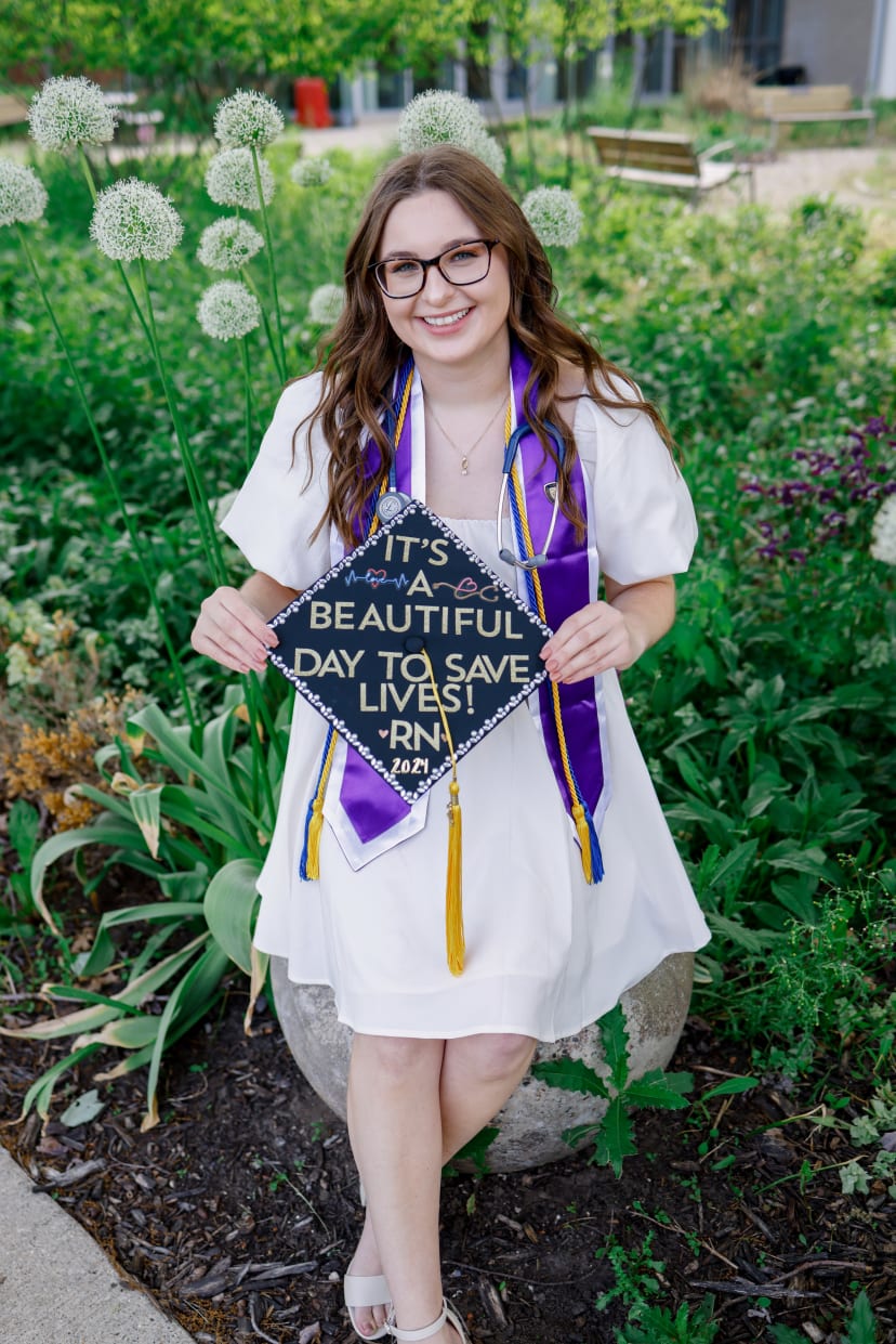 Nursing graduate holding her decorated cap in a garden, Metro Detroit graduation session