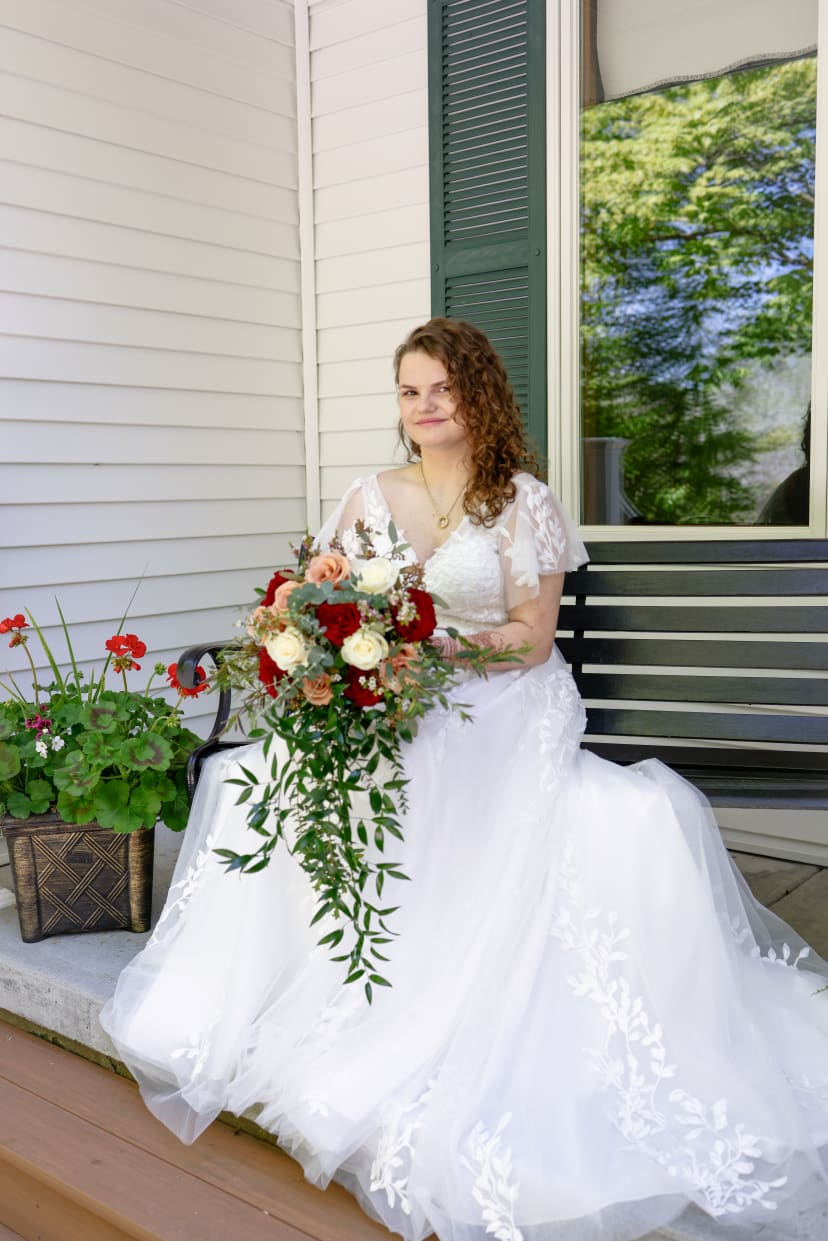 Bride seated on a porch with her cascading bouquet, Metro Detroit wedding