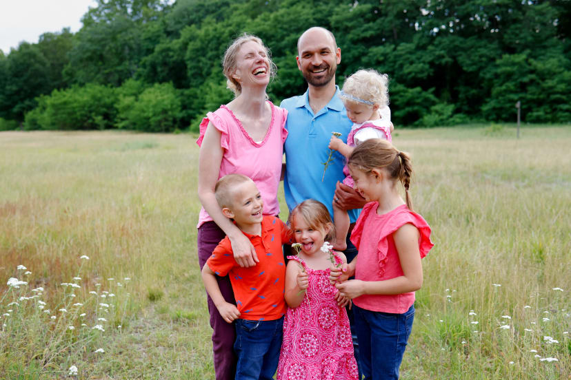 Family of six laughing together in a field, southeast Michigan family session